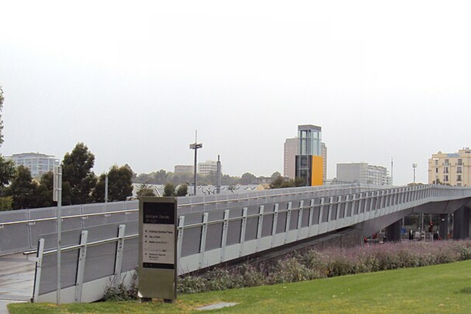 White steel structure of a pedestrian bridge over railway tracks in Melbourne