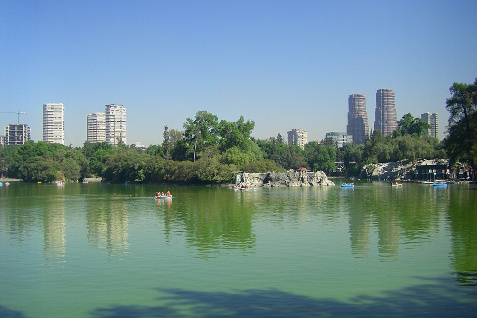A lake with boats among the trees in Chapultepec Park.