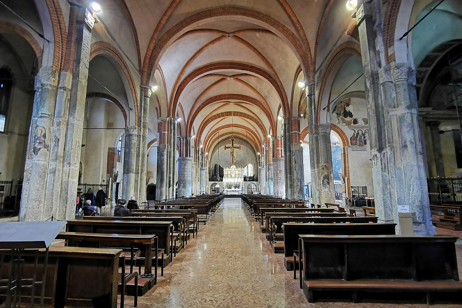 Interior of the Basilica of Sant'Eustorgio: a tall nave, a vaulted ceiling, and a sunbeam falling on the altar