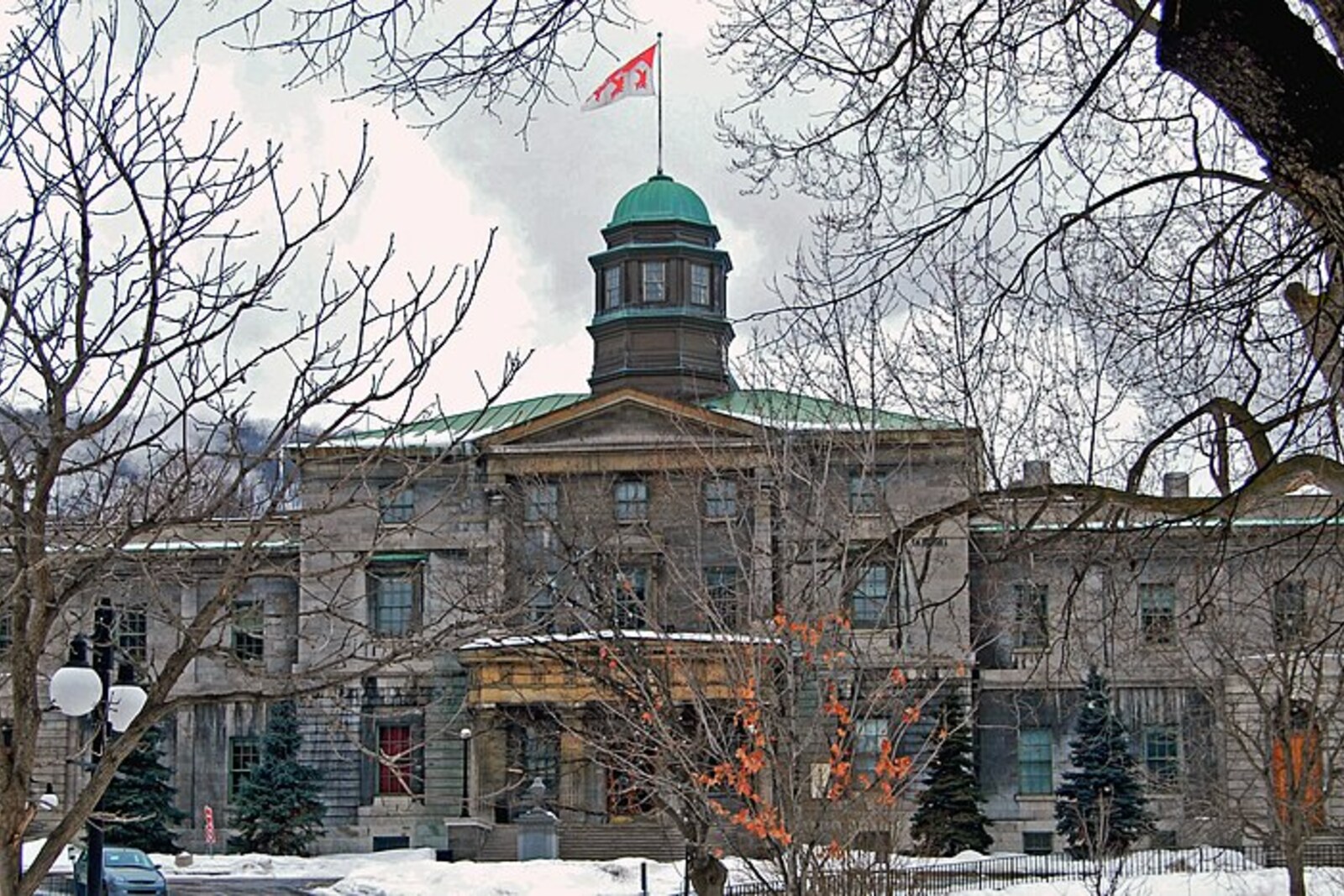 The stone Arts Building at McGill University, with a dome and steps in front of it.