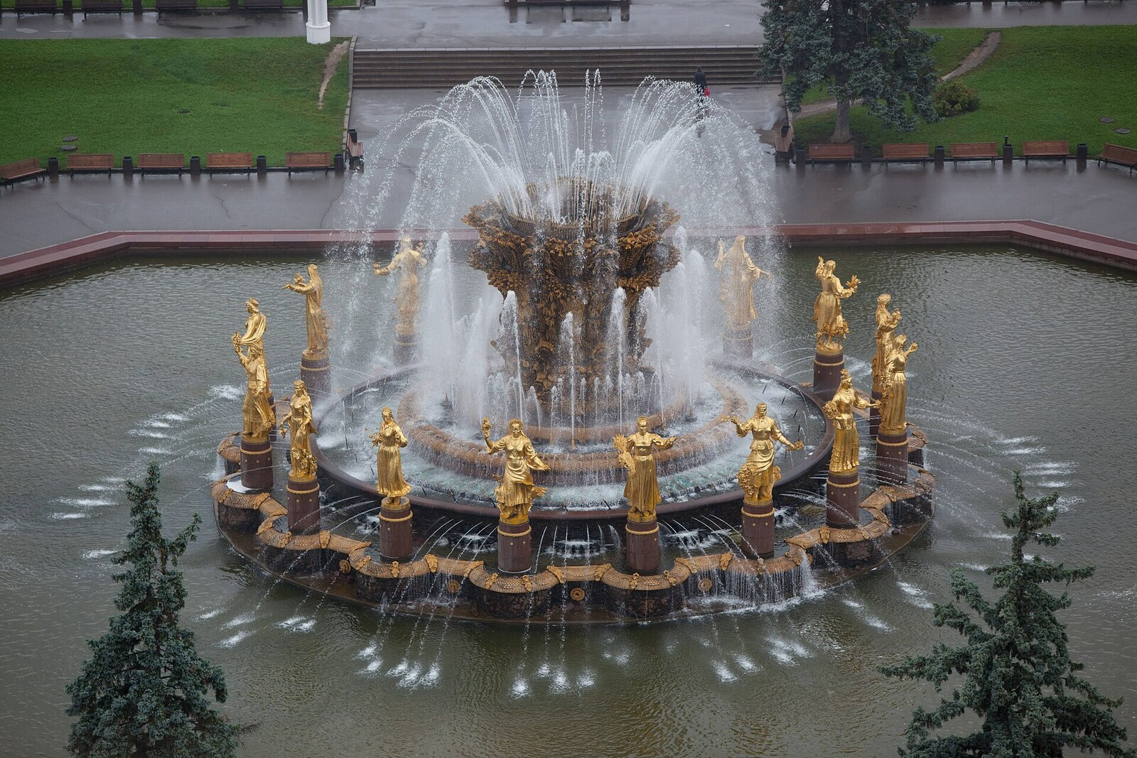 A ring of golden female figures around the Friendship of Nations Fountain.