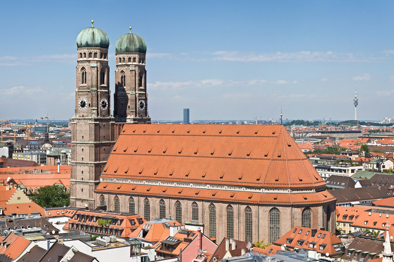 Frauenkirche with two towers and a red roof above old Munich.