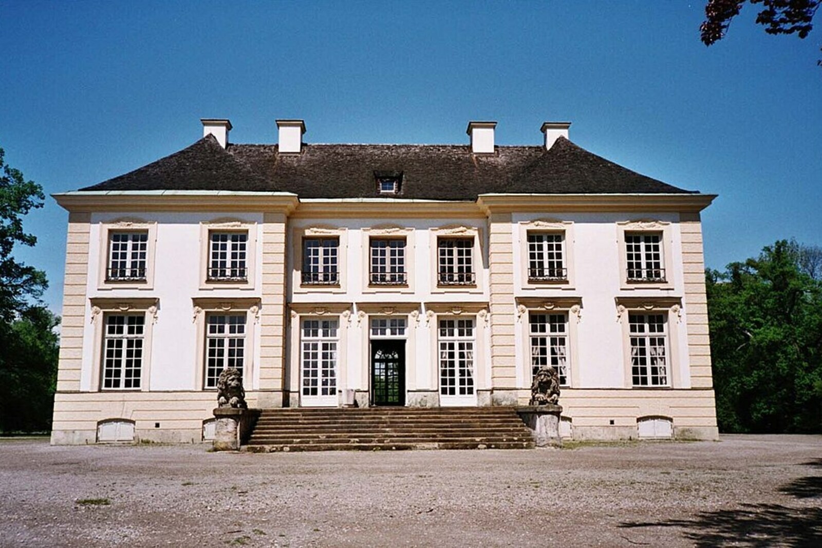 The yellow-and-white building of Badenburg with a pond in front of it.