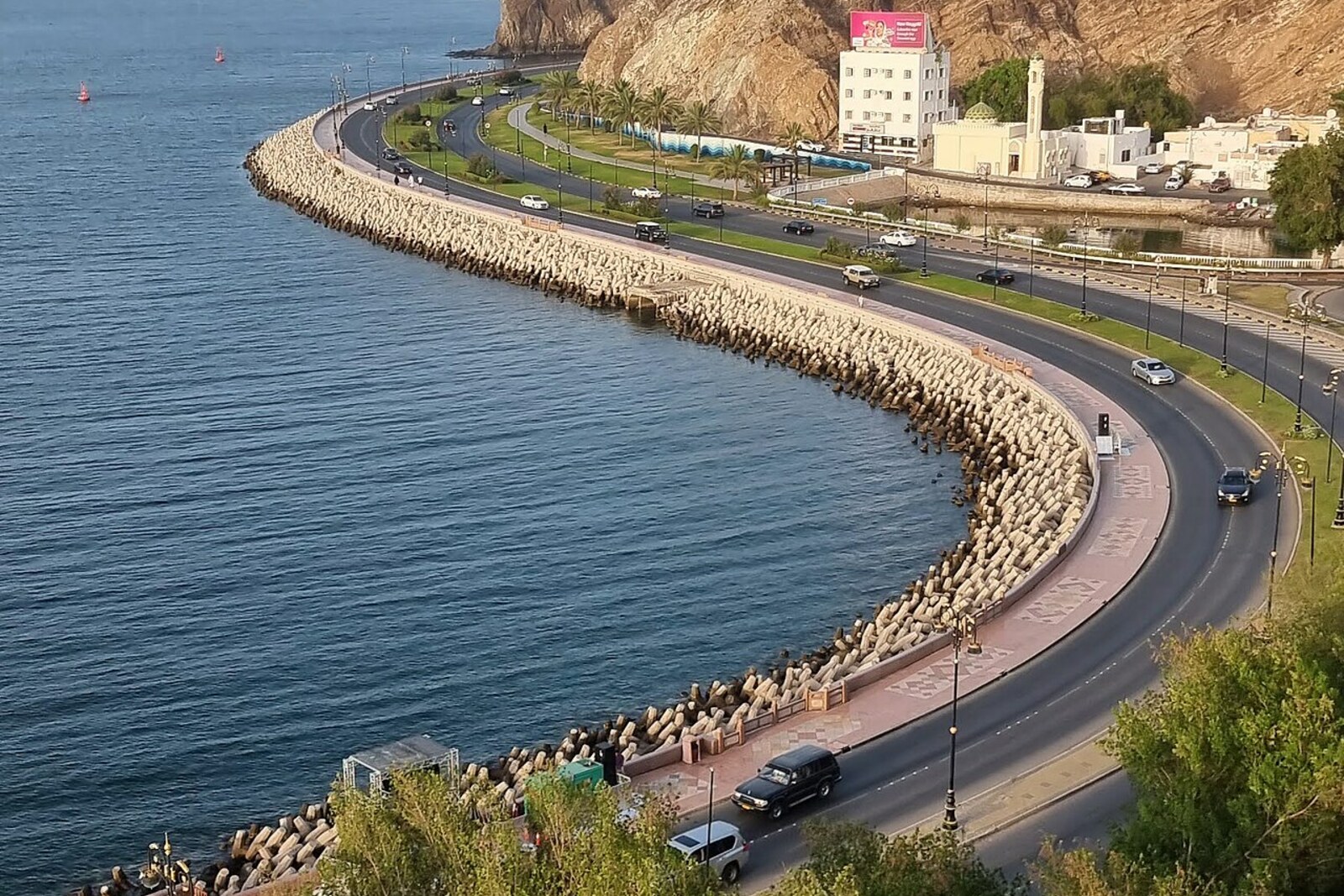 Mutrah's old corniche with white facades by the water.
