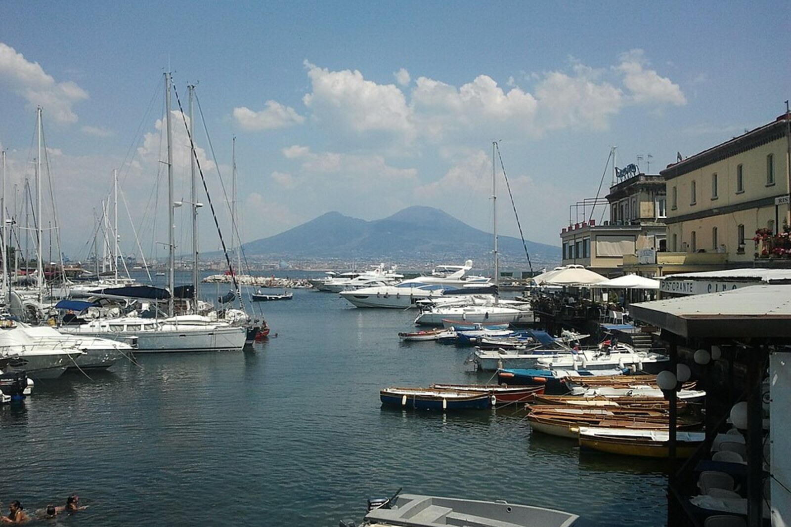 Boats and the shoreline of Porto di Santa Lucia in Naples.