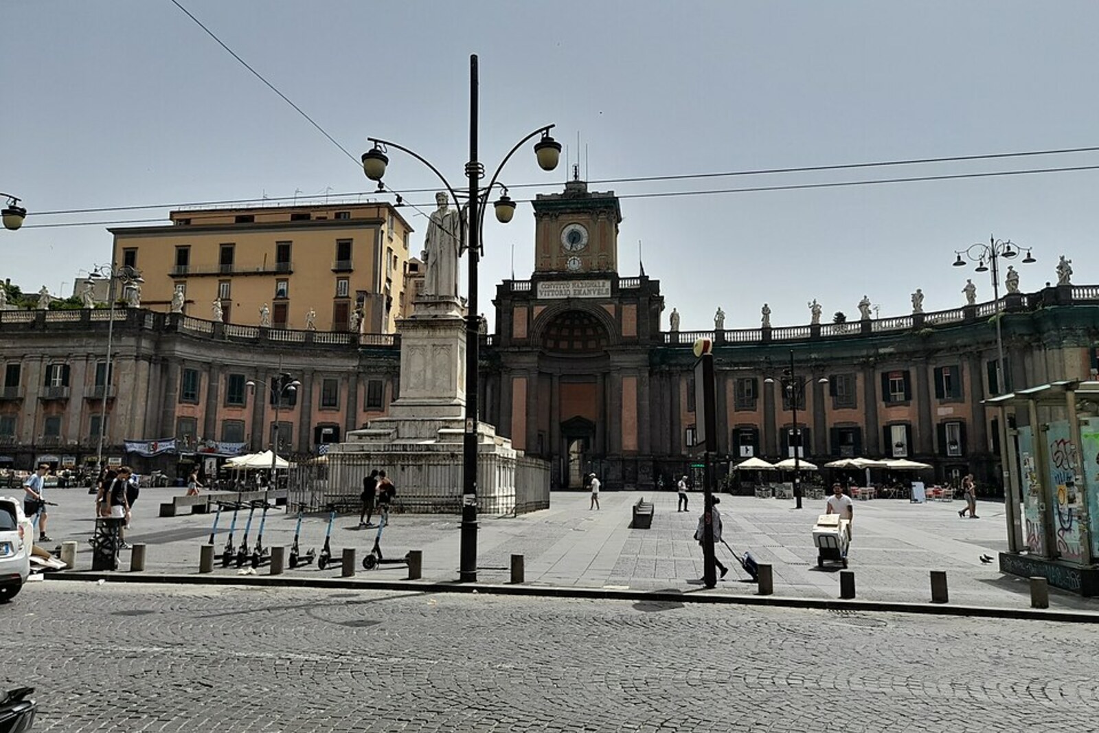Statue of Dante against the backdrop of the semicircular buildings of Piazza Dante in Naples