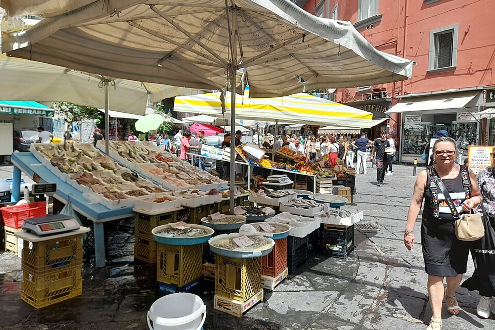 Fruit, vegetables, and passersby at Pignasecca Market in Naples