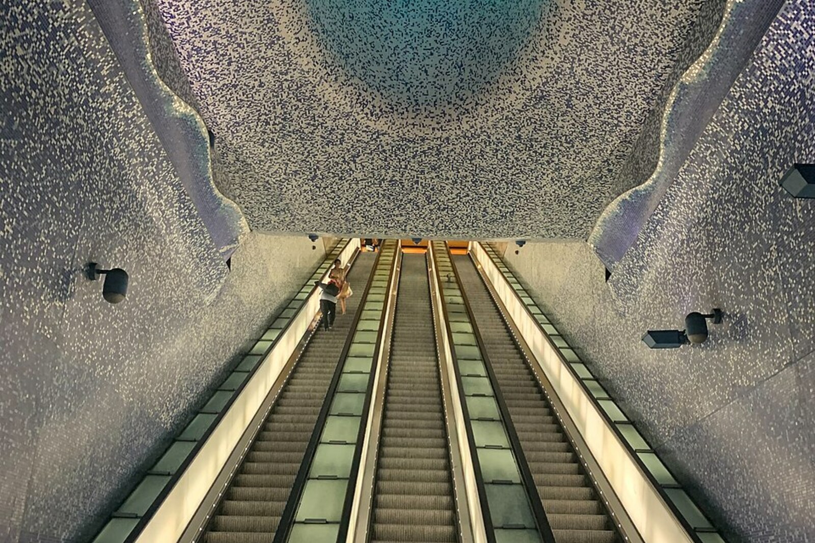 Mosaic walls and a cone of light inside Toledo Metro Station