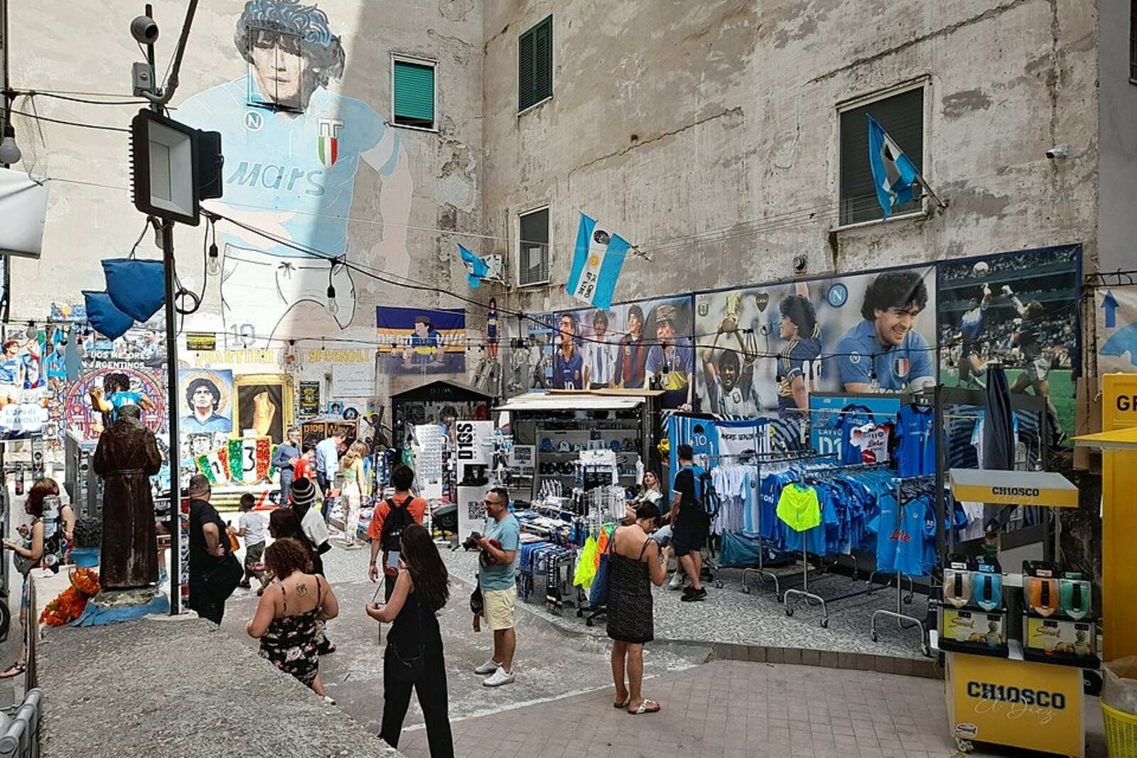 A narrow street in the Spanish Quarter with laundry strung between buildings and a parked motor scooter