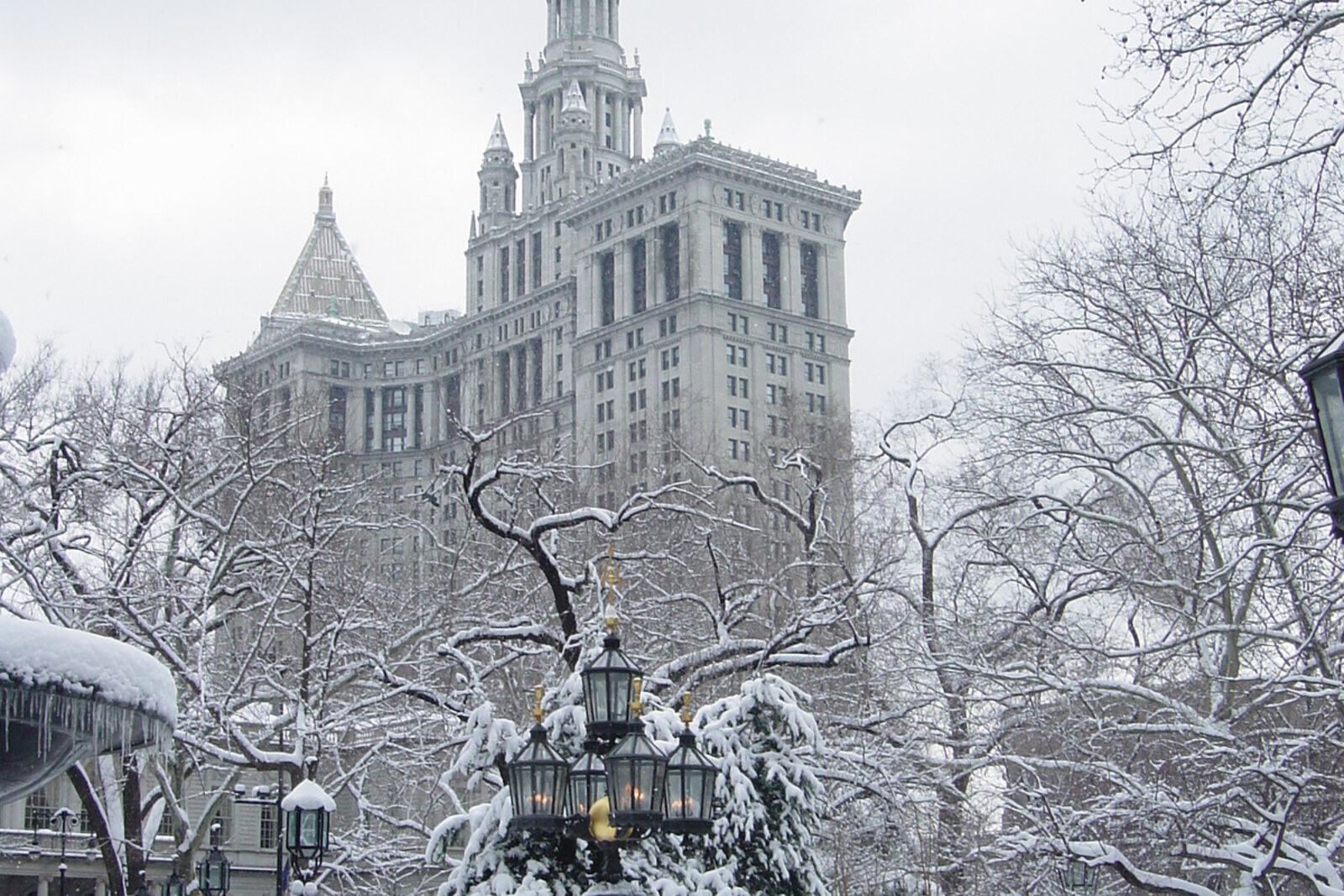 A fountain in City Hall Park in winter, with city buildings in the background