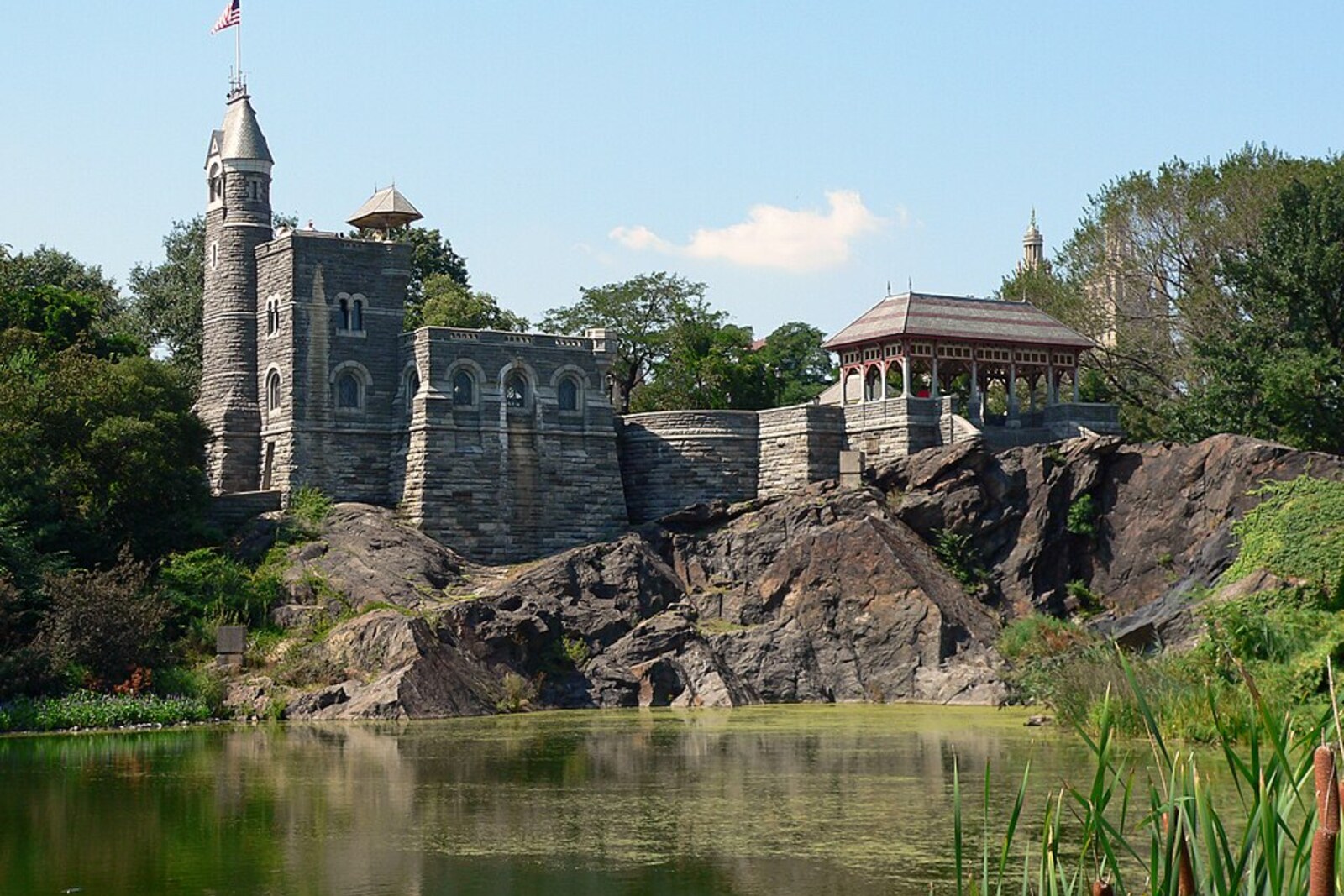 The stone Belvedere Castle with spires on a rocky hill, surrounded by trees