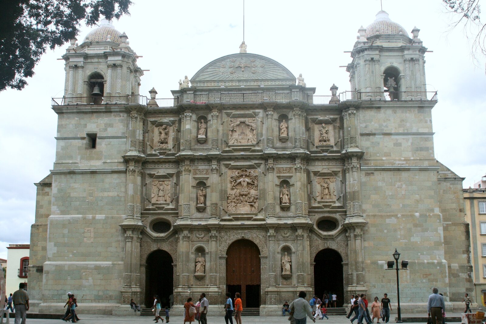 The façade of Oaxaca’s Cathedral with three portals and a heavy stone mass.