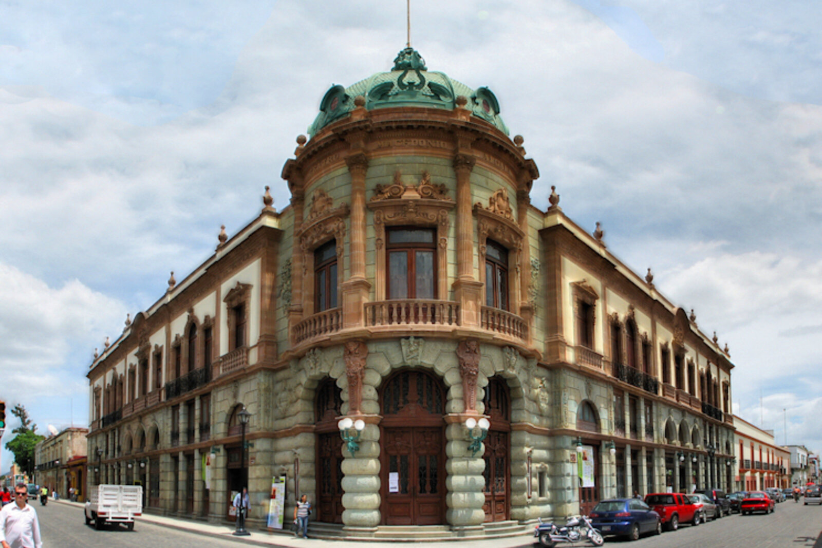 Macedonio Alcalá Theater at a street corner, with a dome and a rounded facade.