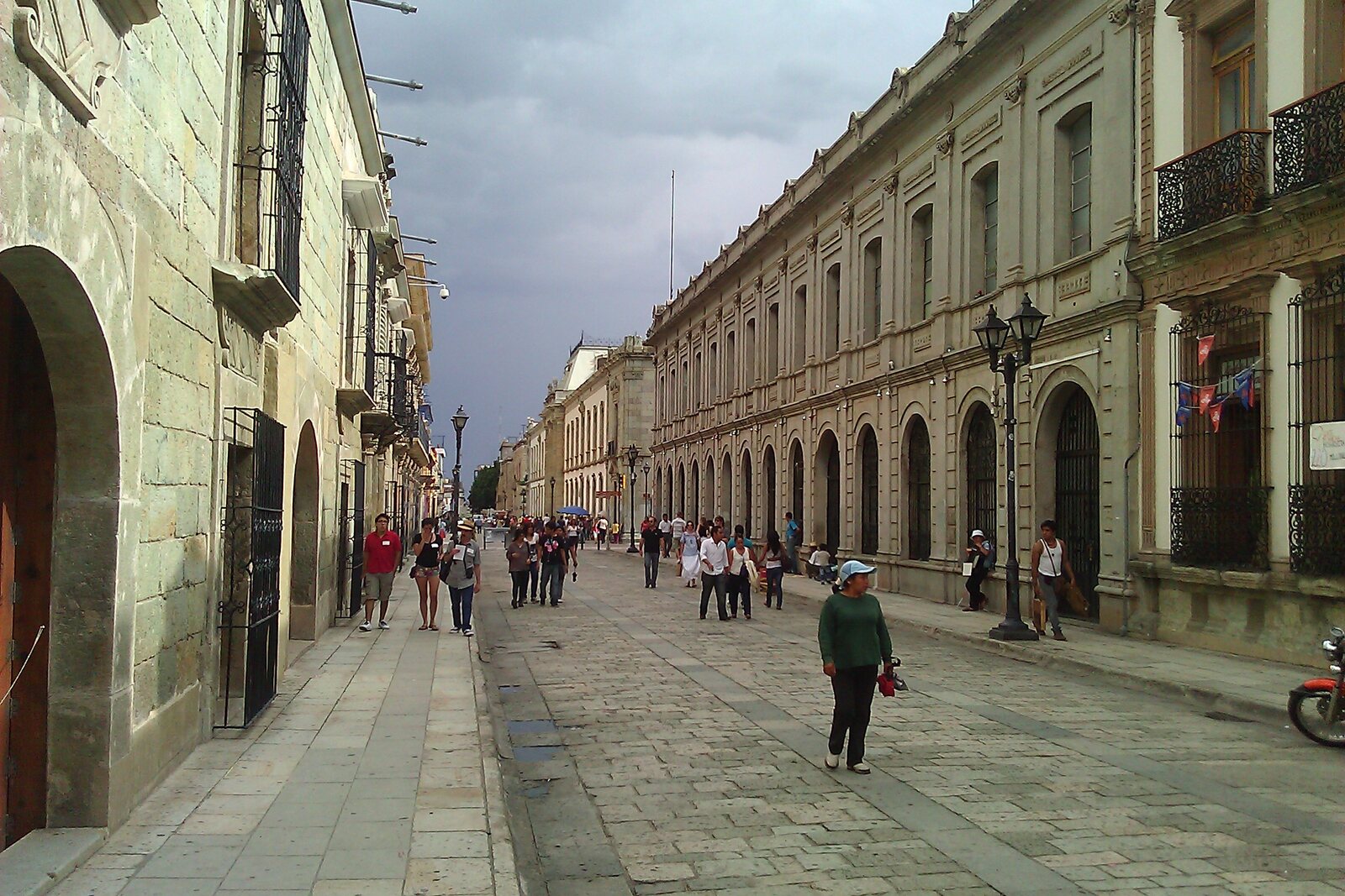A colonial street in Oaxaca's historic center with low façades and stone paving.