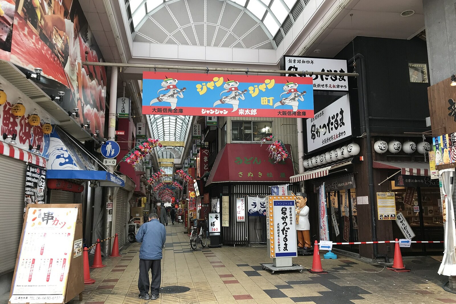 The covered Janjan Yokocho arcade with restaurants and signs, conveying the atmosphere of an alleyway.