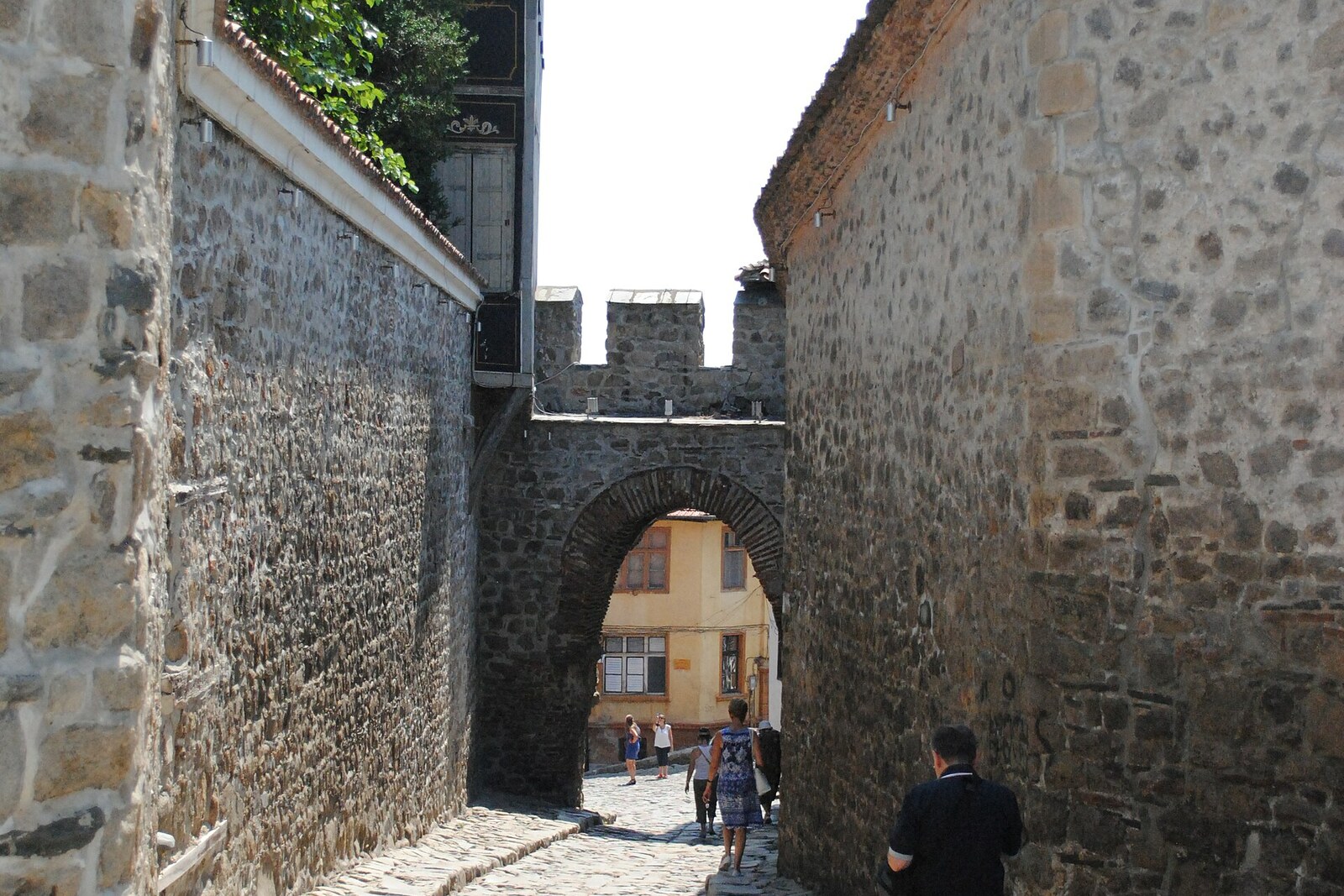 The stone arch of Hisar Kapia in a narrow cobbled lane of the Old Town