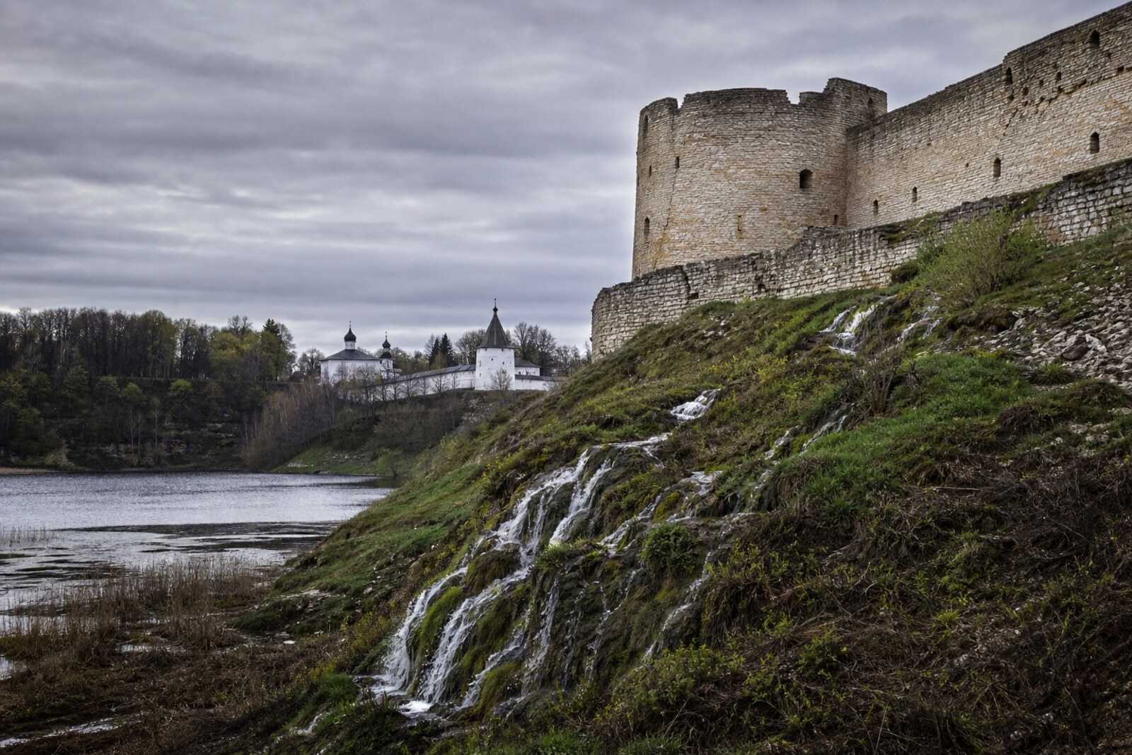 An illustration of a border landscape with a fortress wall, springs, and a monastery in a ravine.
