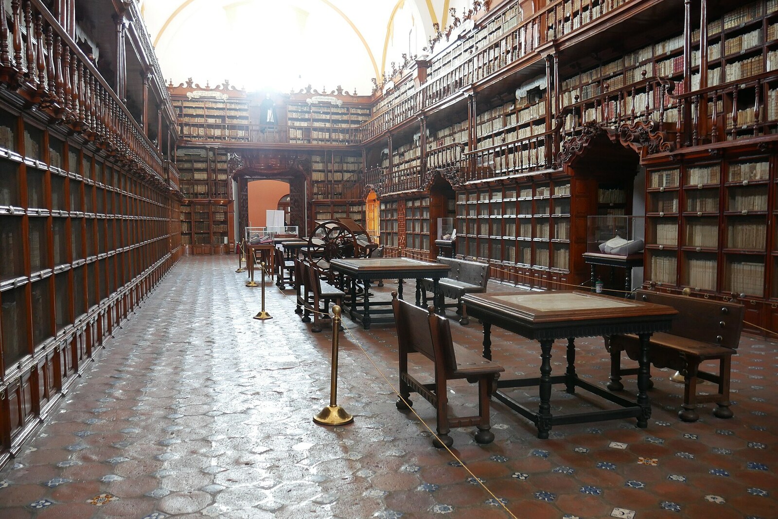 The long hall of the Palafoxiana Library with tall wooden bookcases.