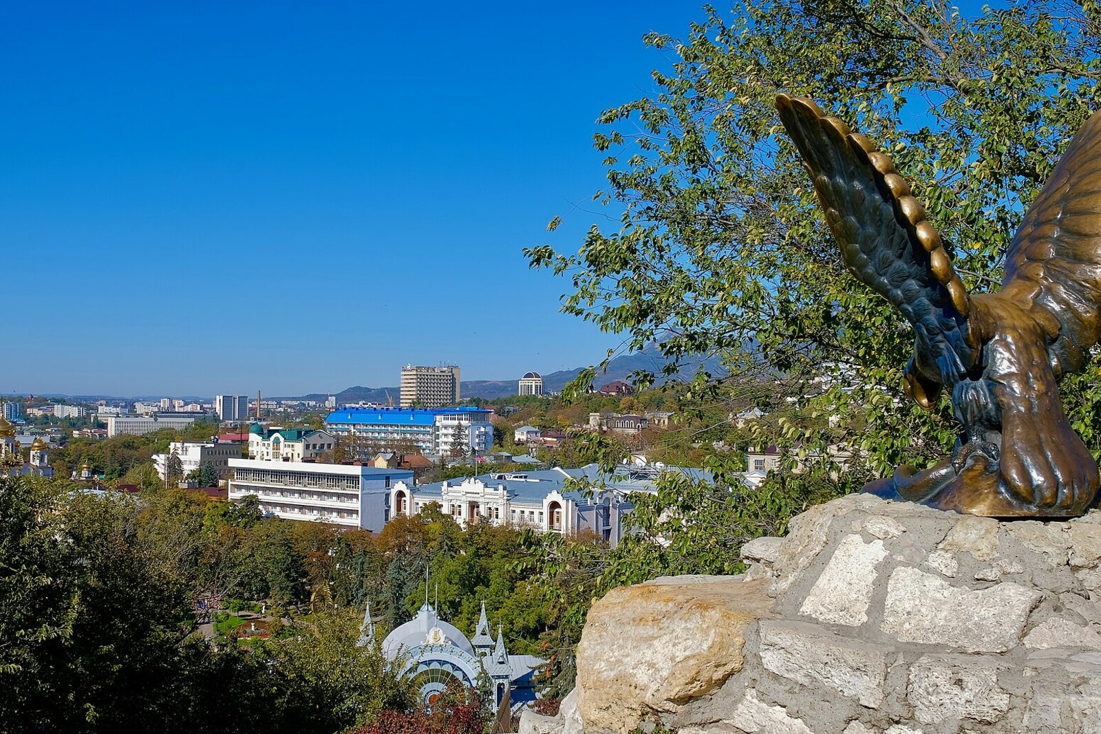 A bronze eagle holding a snake on a stone ledge above Pyatigorsk.
