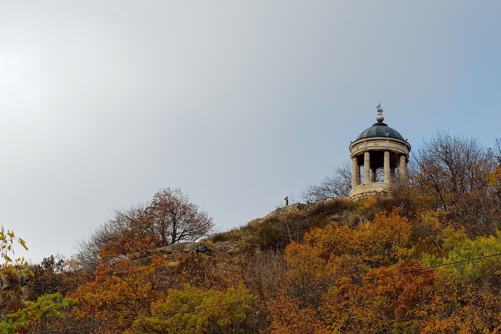The white rotunda of the Aeolian Harp on the forested slope of Mount Mashuk.