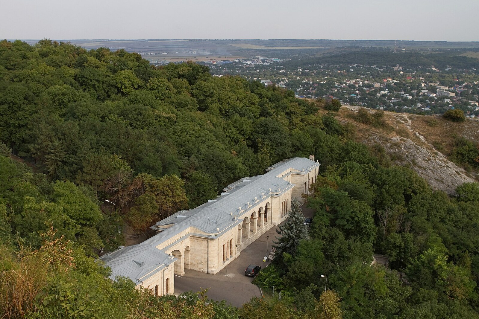 The white Academic Gallery with a long arcade between green slopes.