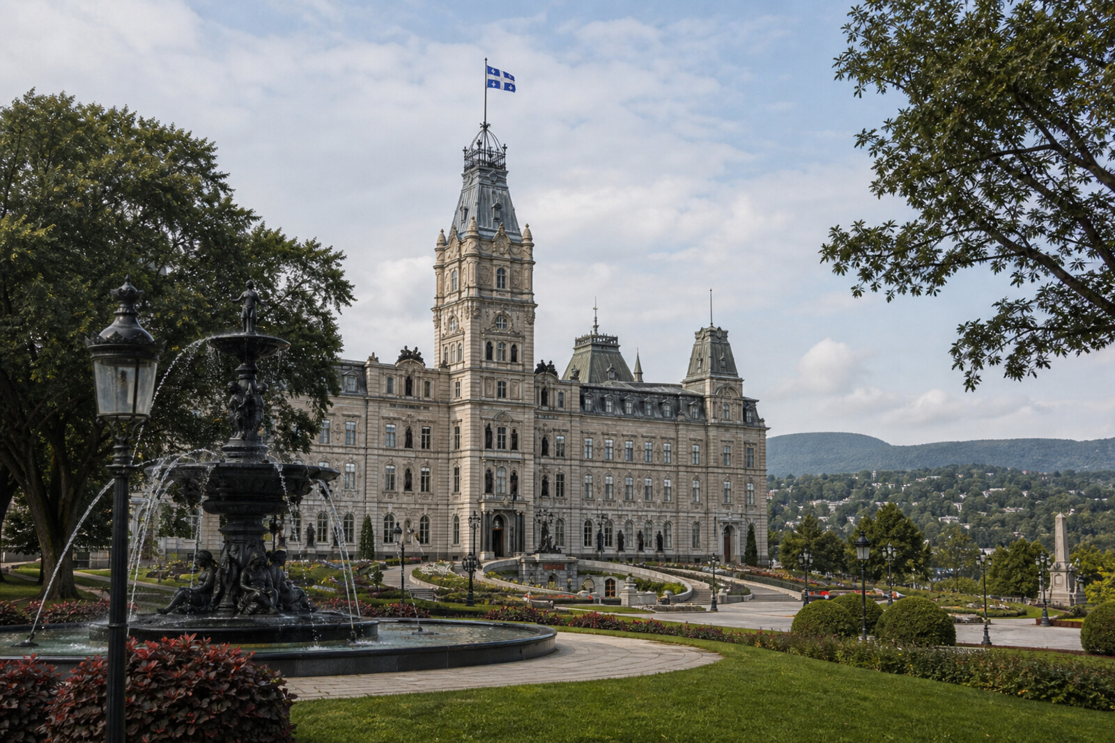 View of Parliament Hill in Québec City, a fountain, trees, and a modern glass pavilion against the green fields.