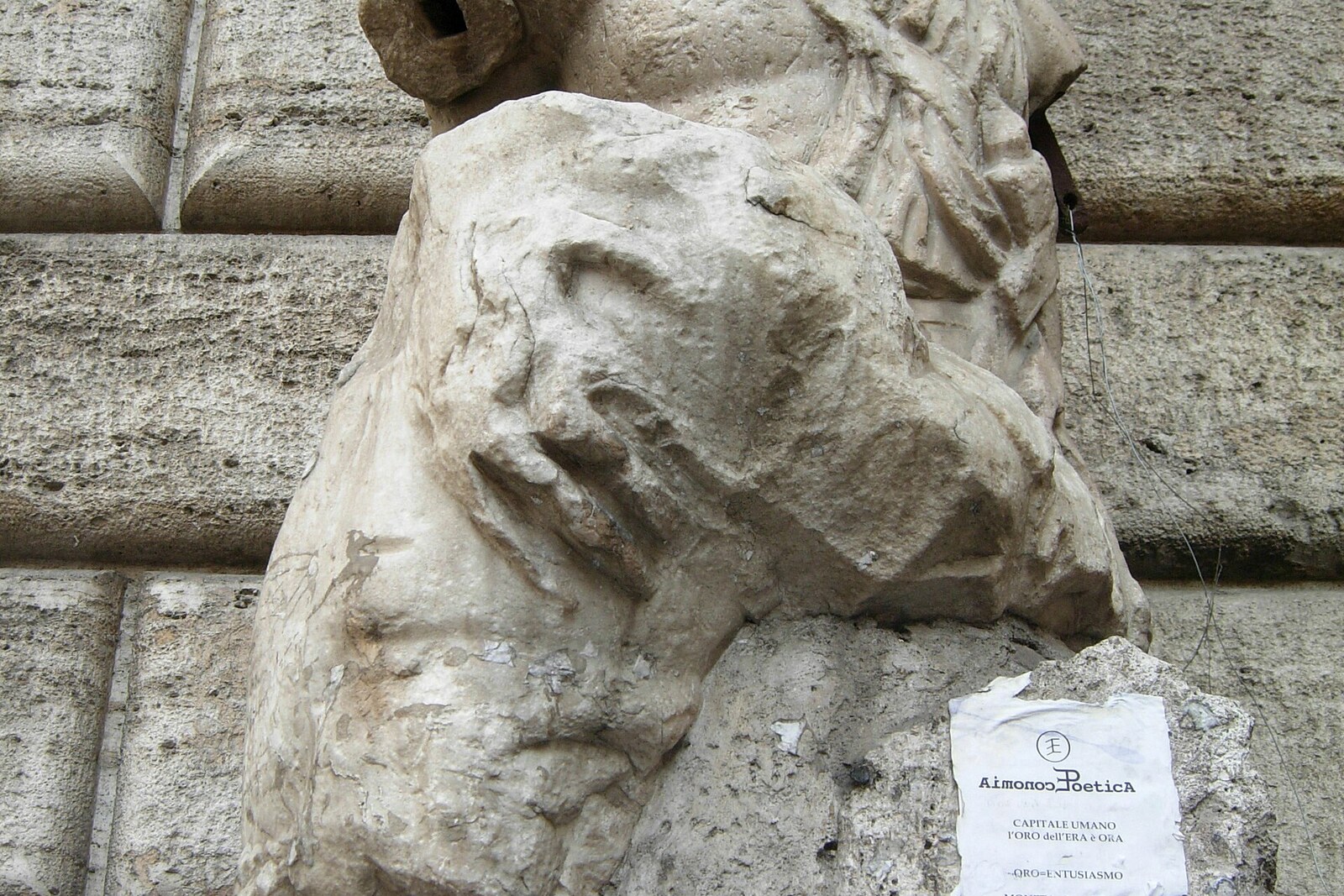 The stone statue of Pasquino at the corner of a building, with notes at its base