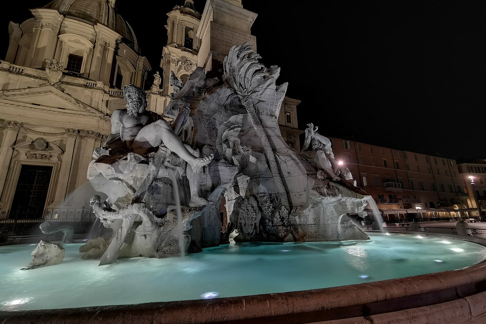 The illuminated Fountain of the Four Rivers on Piazza Navona with its obelisk at night