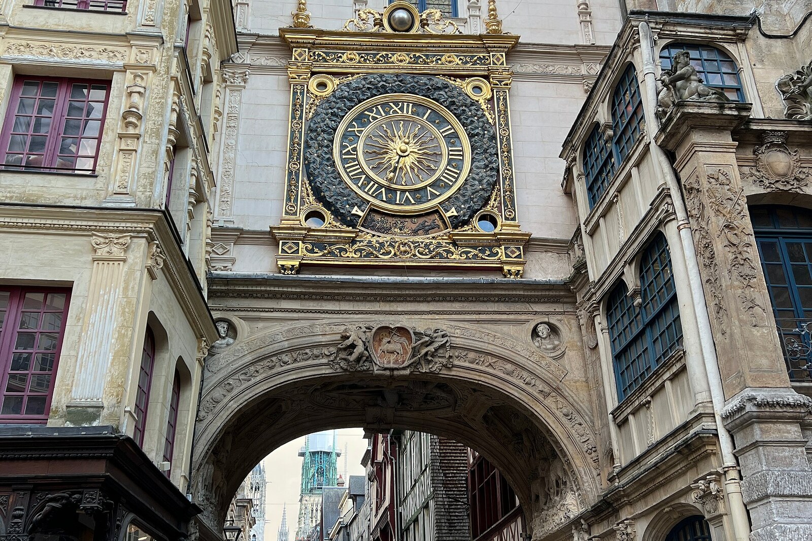 The golden dial of the Gros Horloge above the street arch in Rouen.
