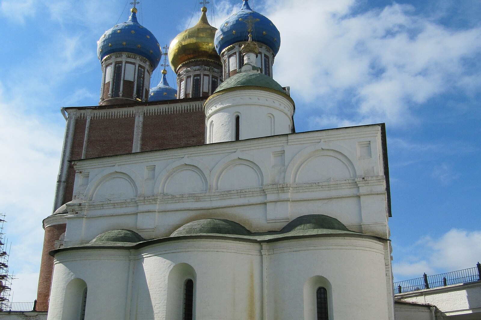 The white Archangel Cathedral against the domes of Assumption Cathedral