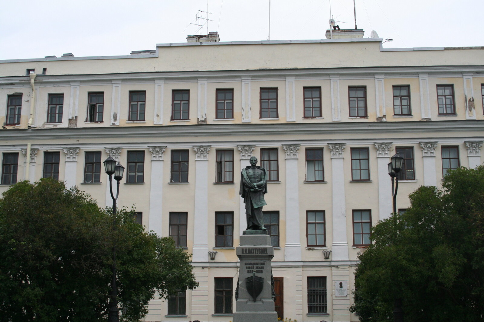 The light-colored facade of the Italian Palace and the Monument to Pyotr Pakhtusov in Kronstadt.