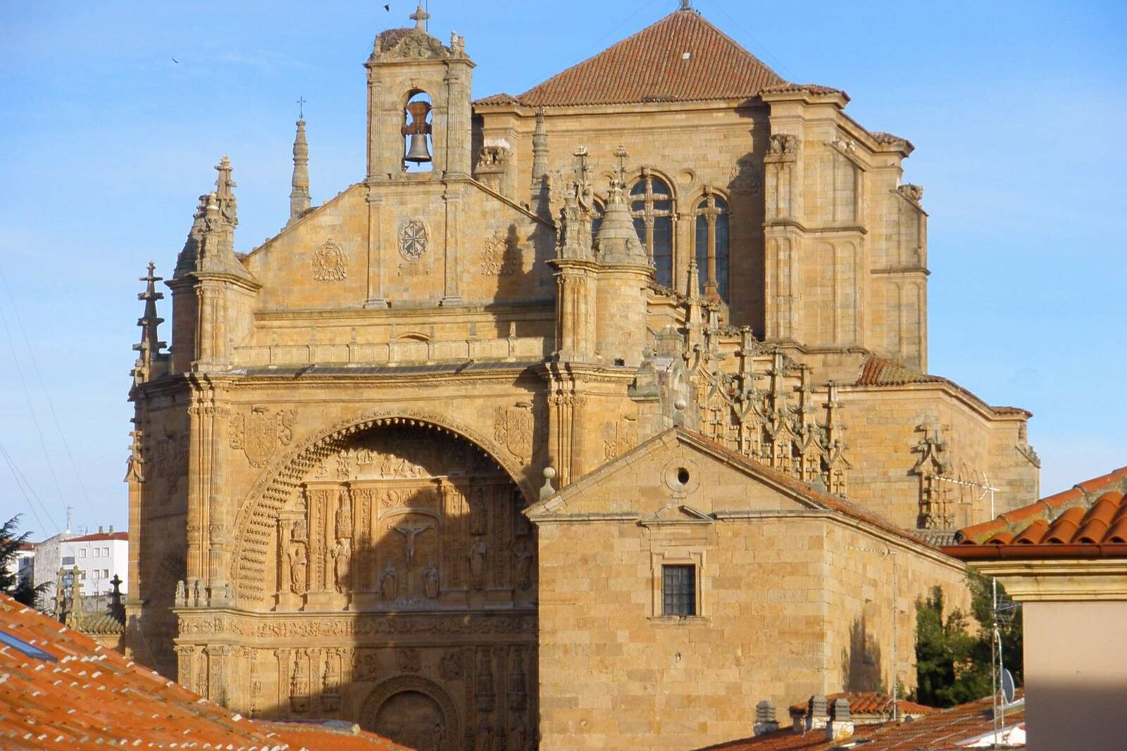 The carved façade of the Convent of San Esteban beneath a large stone arch.