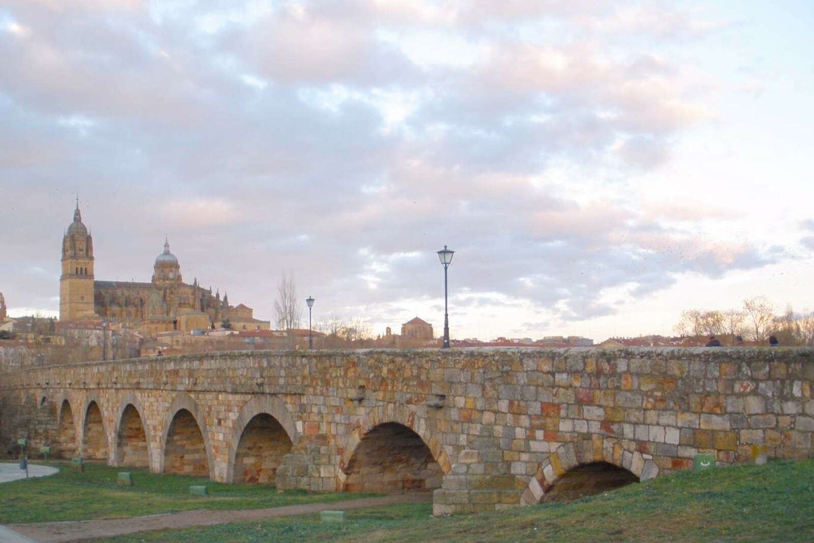 The Roman Bridge of Salamanca across the Tormes, with the silhouette of Salamanca beyond it.