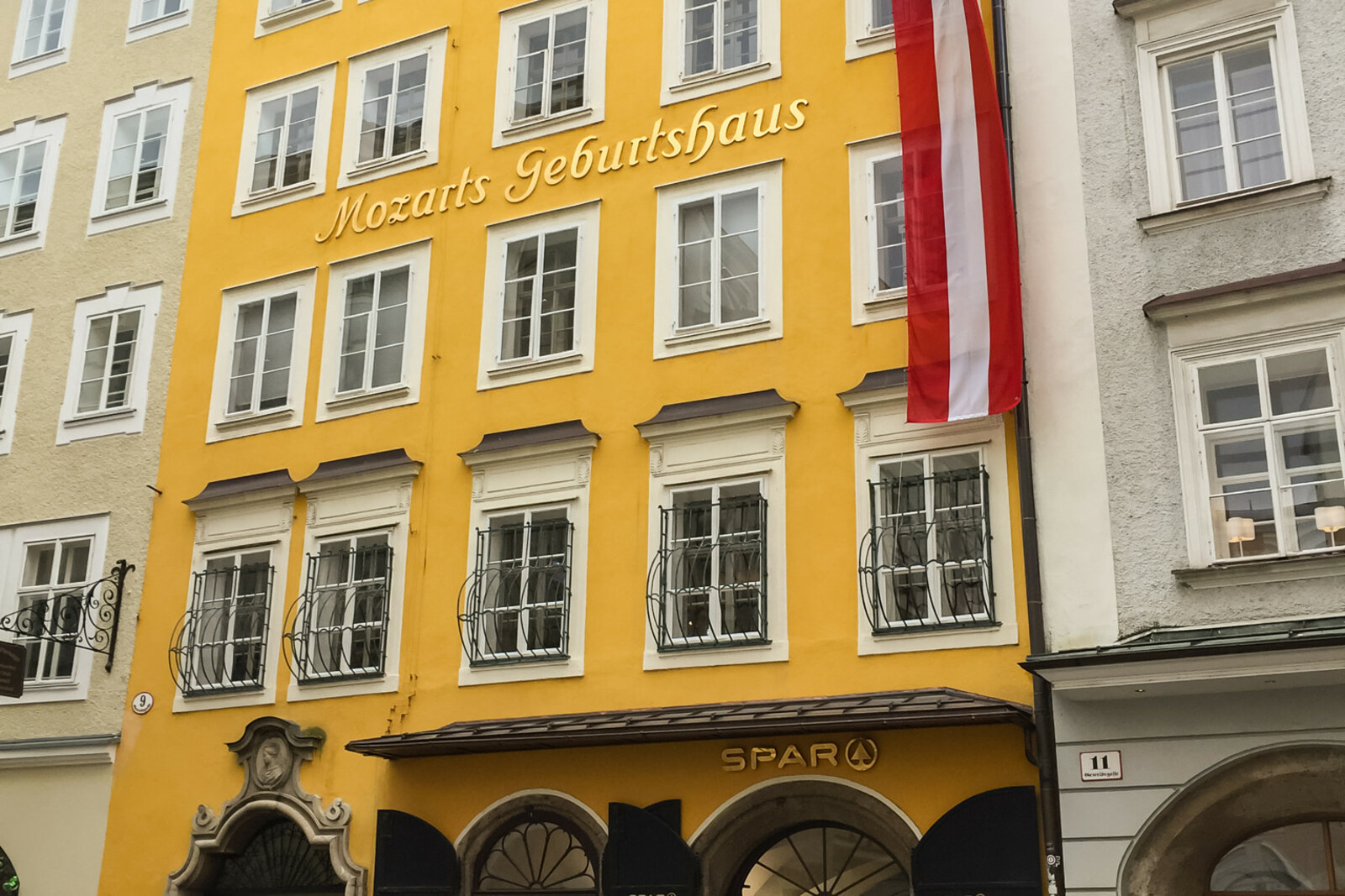 Bright yellow house with an Austrian flag and narrow windows