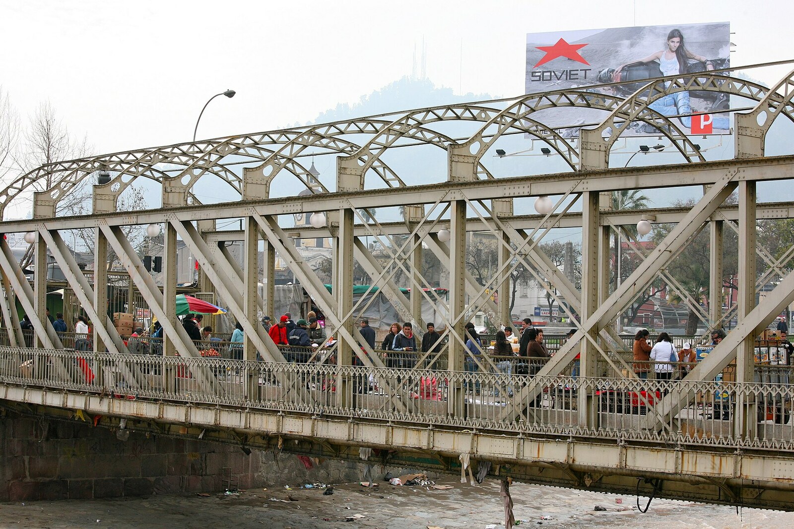 Pedestrians cross Pío Nono Bridge over the Mapocho River.