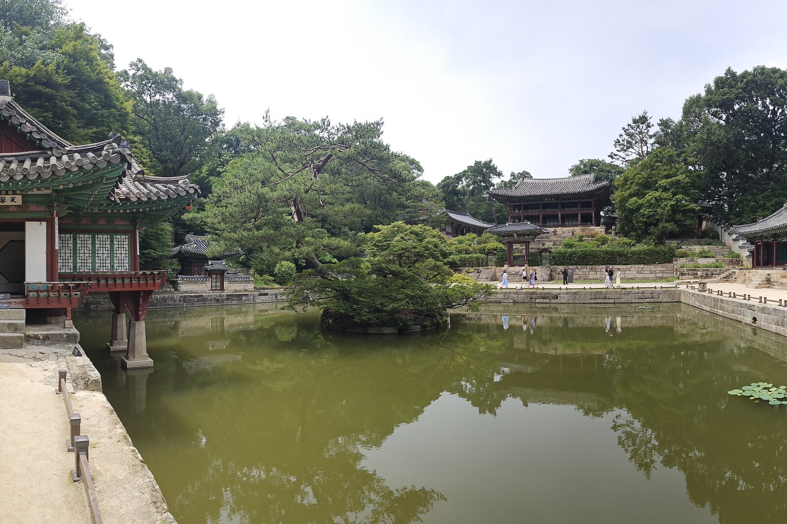 Buyongji Pond with a pavilion, an island, and the green slope of Huwon.