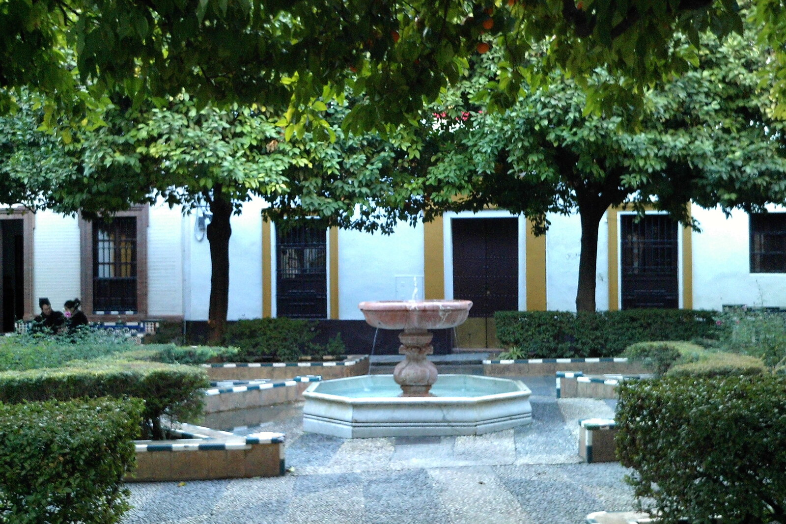 Plaza de Doña Elvira with an octagonal fountain, orange trees, and white houses.