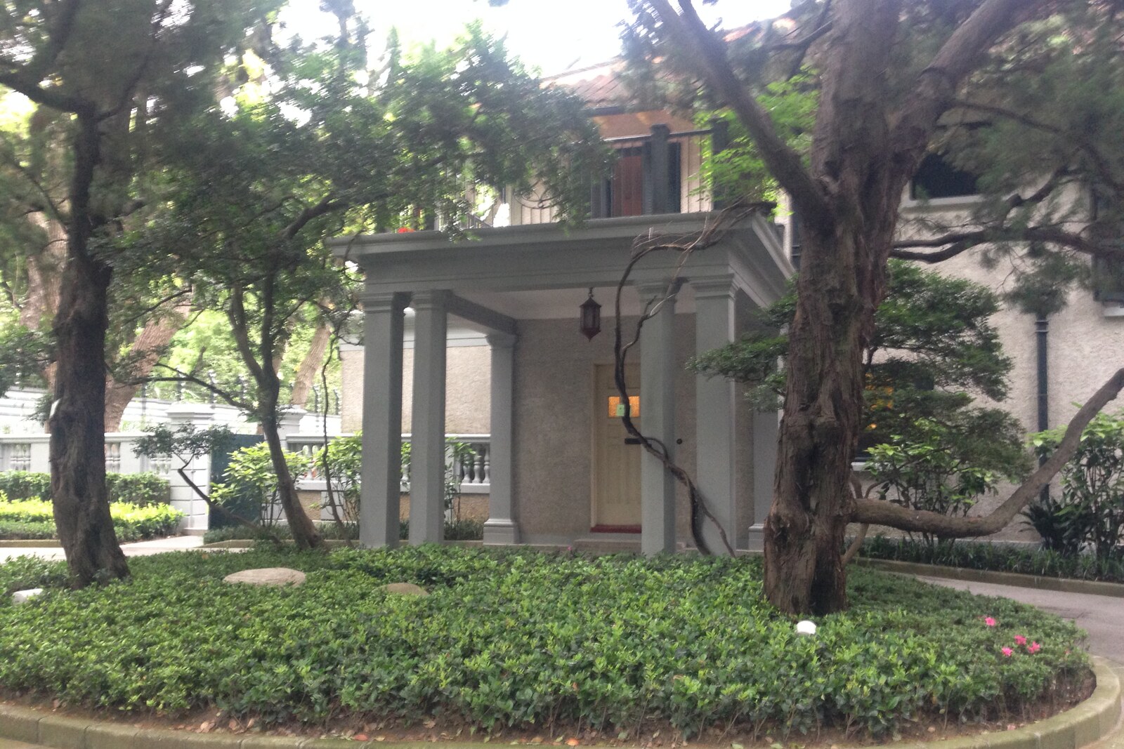 Former Residence of Soong Ching-ling, a white two-story villa with shrubs in front of the facade