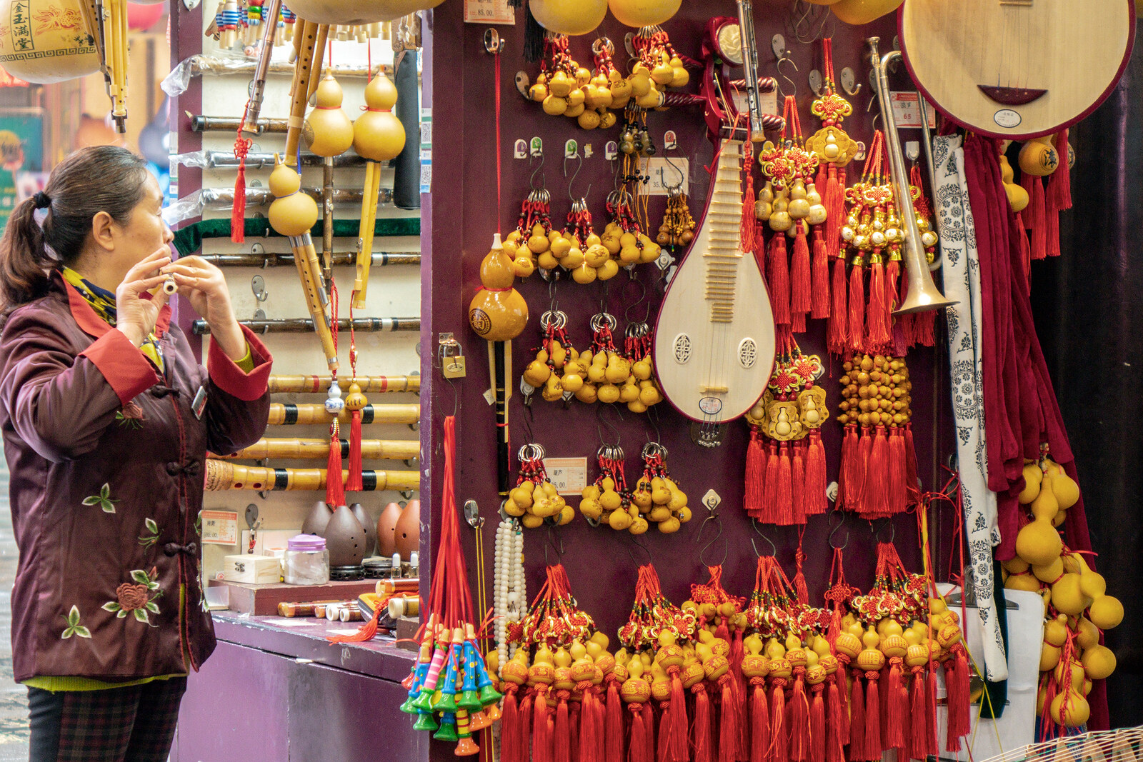 Ein Händler auf dem Yuyuan-Markt mit roten Laternen und alten Gebäuden