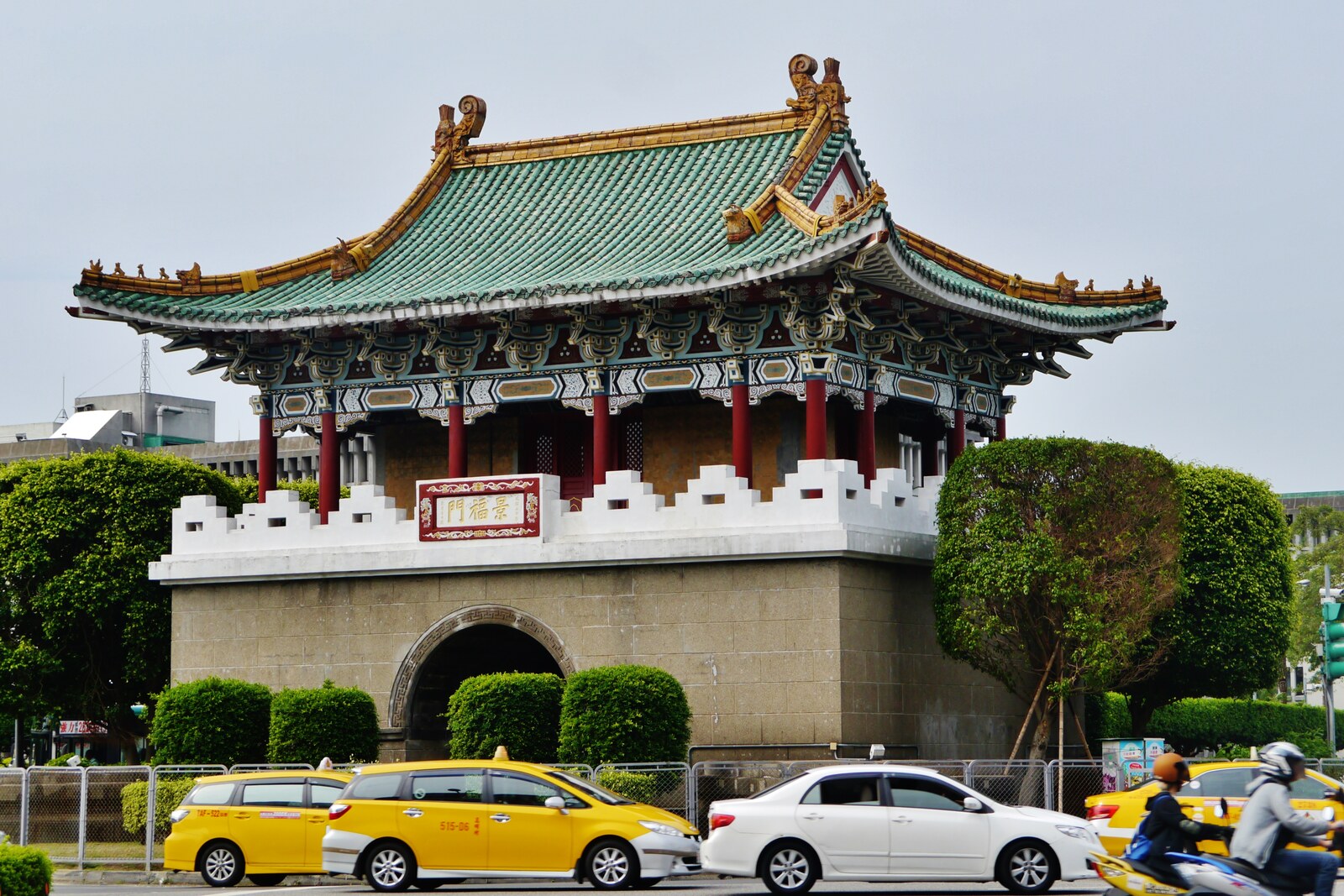 Traditional Chinese gate with red walls and a green roof