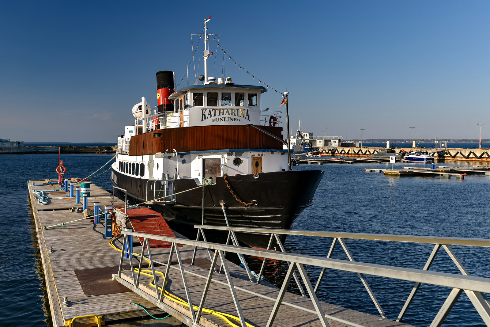 Yachts at the pier in Noblessner Port and red-brick workshops