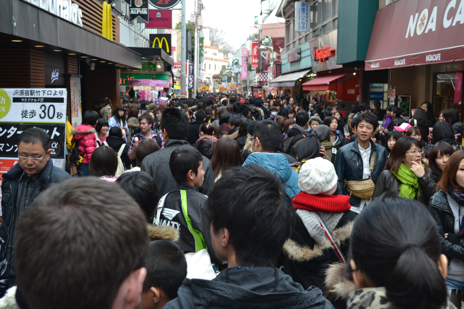 The narrow Takeshita Street with bright signs, a crowd of people, and shops