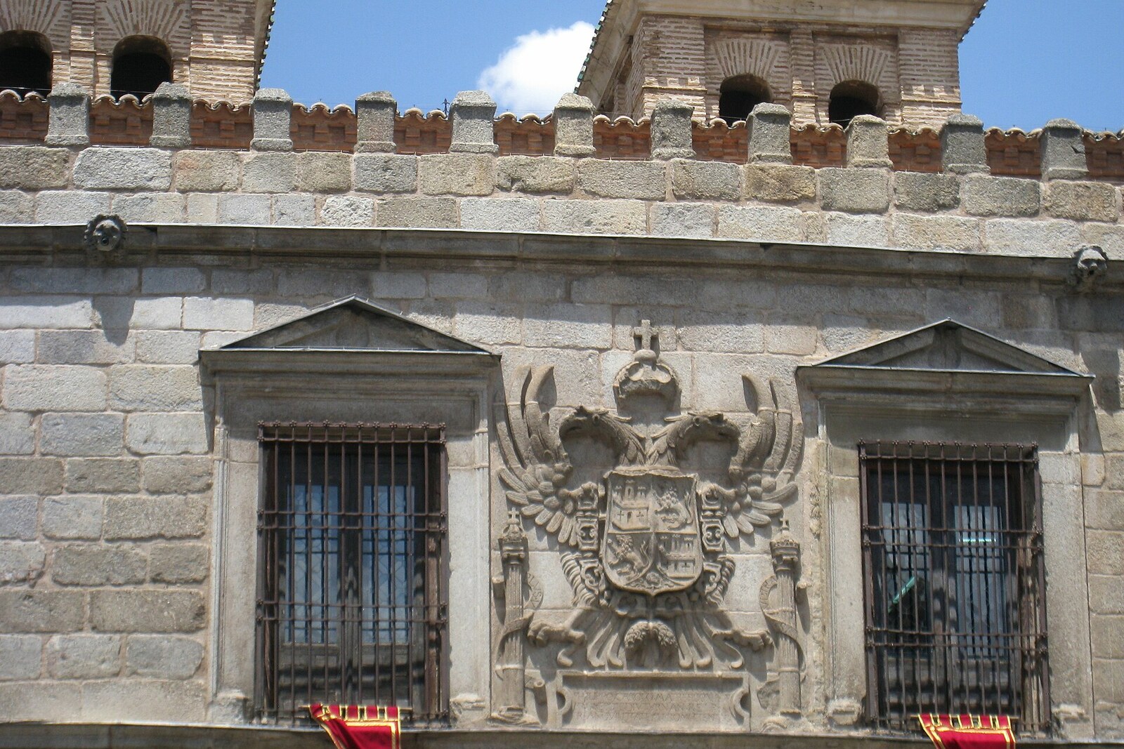 The stone gates of Puerta de Bisagra, with a round tower and an imperial eagle above the arch.