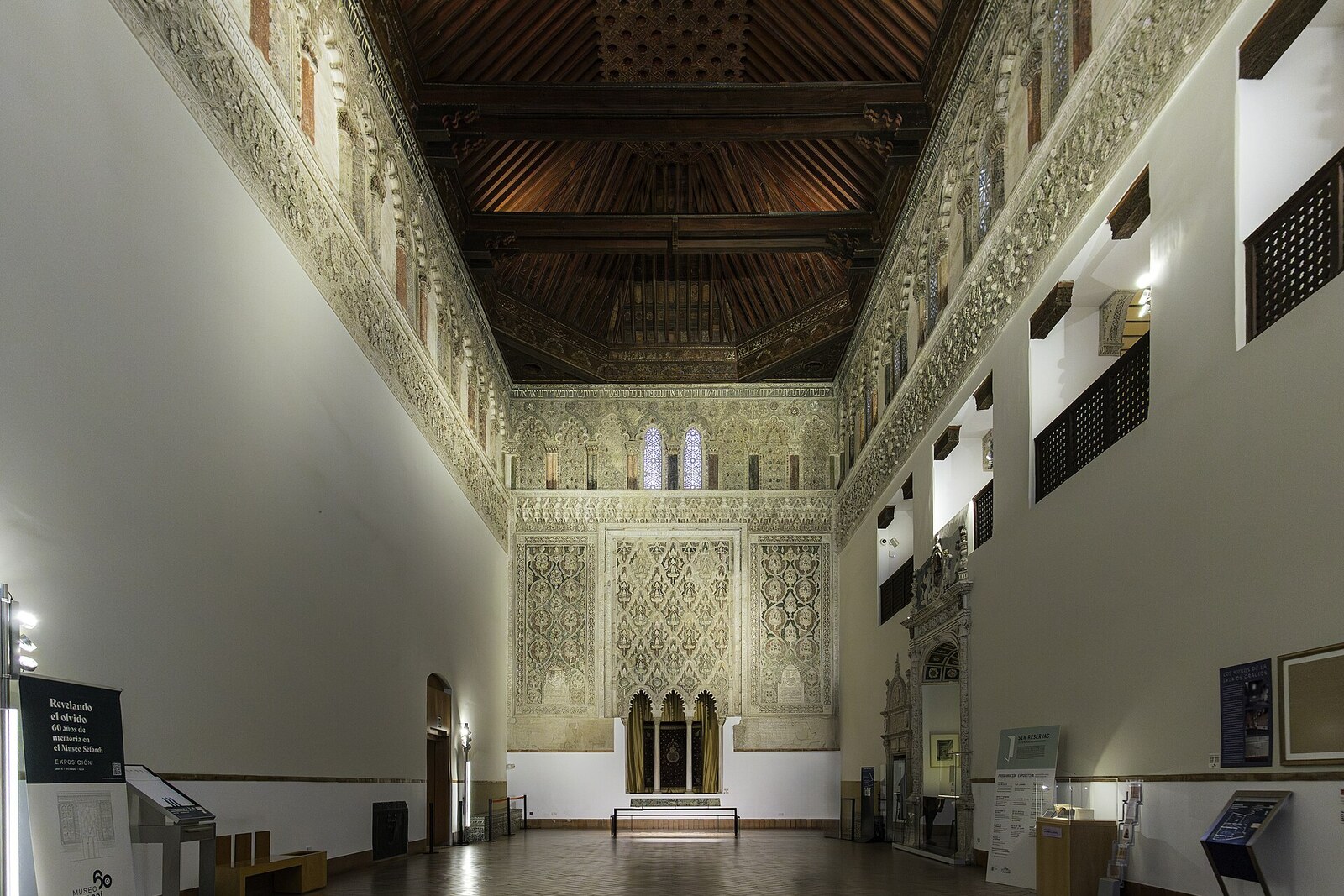 The prayer hall of El Tránsito with carved walls and a wooden ceiling.