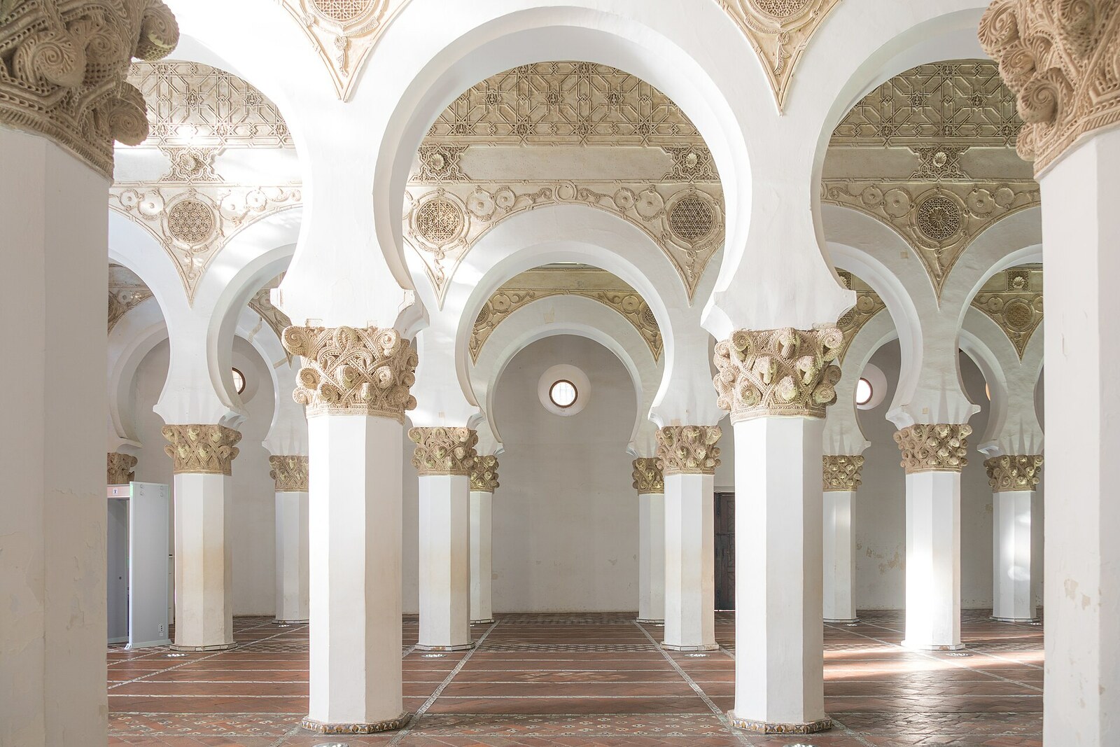 White rows of horseshoe arches and carved capitals in Santa María la Blanca.