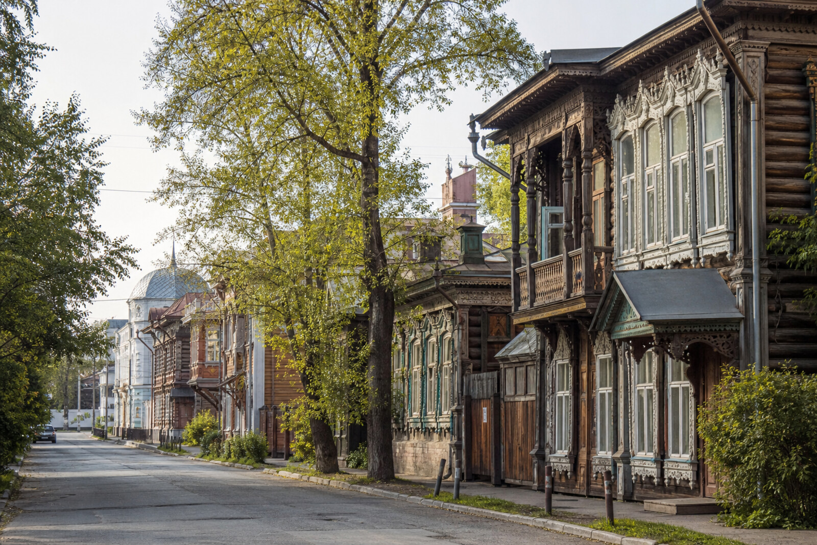 A wooden street in Tomsk with carved window frames and the silhouette of a university town.
