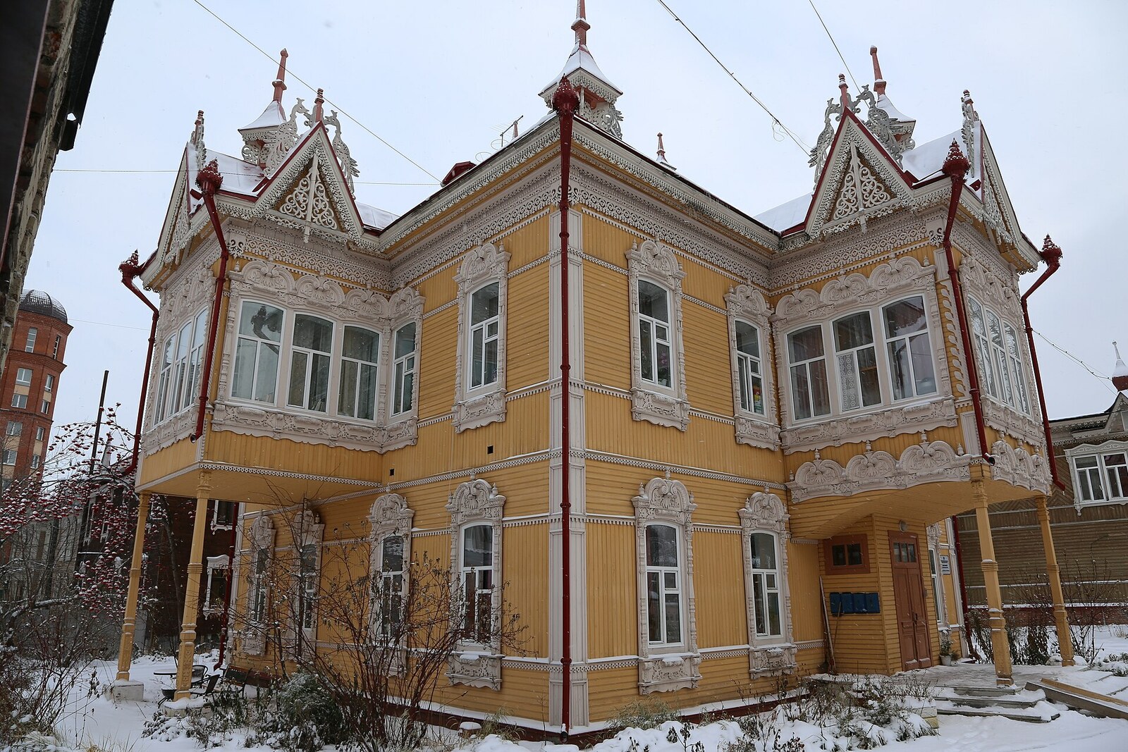 Carved facade of a wooden house with firebird figures.