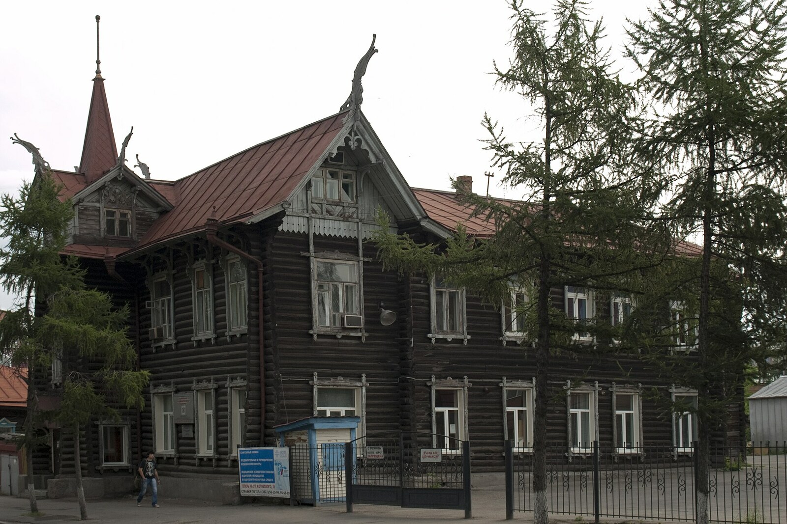 A wooden house with carved dragon heads on its roof.
