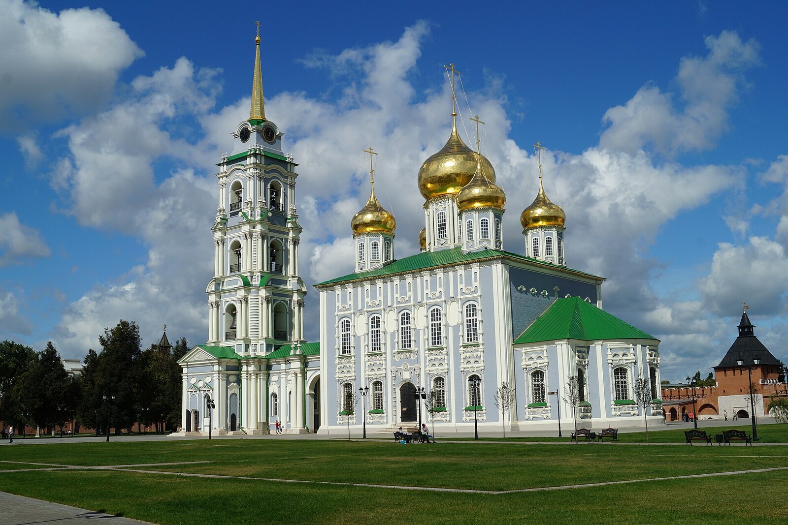 The white-and-green Assumption Cathedral with golden domes and a tall clock bell tower.