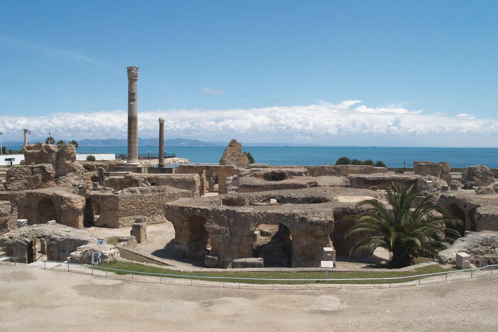 Ruins of the Antonine Baths with arches and columns against the backdrop of the sea.